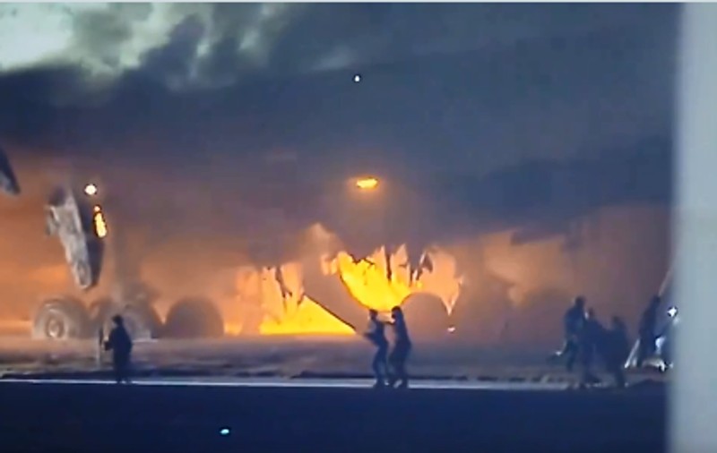 Pasagerii din avionul care a luat foc pe aeroportul din Tokyo, filmaţi pe pistă, în timp ce fug să se salveze. VIDEO