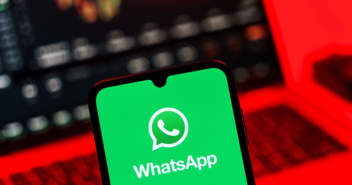 Smartphone așezat pe o masă, pe ecranul căruia este afișat logo-ul WhatsApp