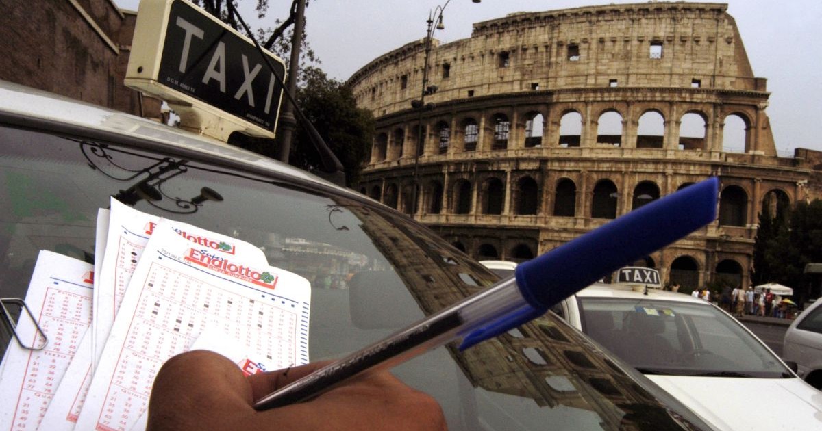 Un șofer de taxi selectează numere pentru a juca la principala loterie a Italiei, cunoscută sub numele de SuperEnaLotto, în fața Colosseumului, pe 13 august 2003, la Roma, Italia