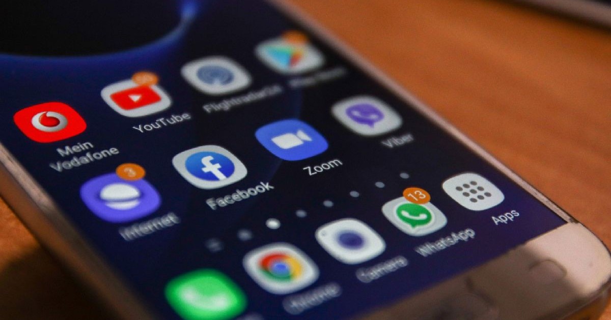 Ecranul aprins al unui smartphone, pe care se văd pictograme ale aplicațiilor