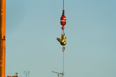 The new golden rooster containing relics is lifted by crane to be installed atop the spire of Notre Dame cathedral as part of its reconstruction, in central Paris on December 16, 2023. The golden rooster, designed by architect Philippe Villeneuve, contains relics saved from the fire that struck the monument on April 15, 2019, and a document with the names of those working on its reconstruction. Photo by Alexis Jumeau/ABACAPRESS.COM