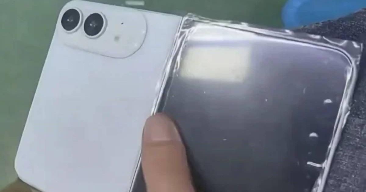 O machetă iPhone Ultra, de culoare albă, ținută în mână în poziția depliată.