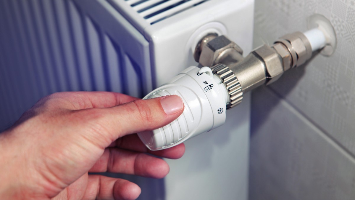 Bărbat care reglează temperatura caloriferului