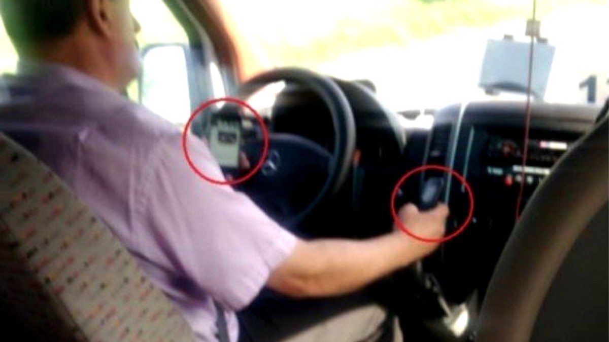 Un șofer de microbuz conducea doar cu coatele. Șofer de microbuz cu două telefoane mobile în mâini (ARHIVĂ)