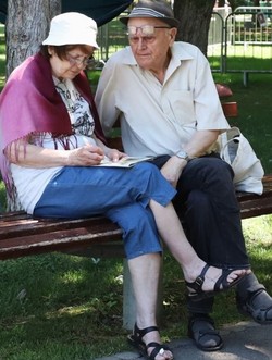 Un cuplu de pensionari stă pe o bancă în parc. Foto: Libertatea/ Dumitru Angelescu