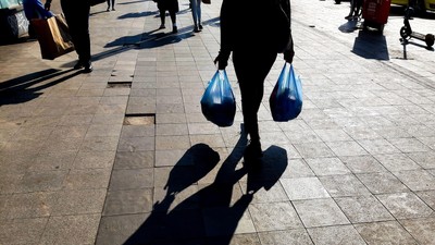 Bucharest, Romania - October 20, 2021: People with shopping bags walk on a street in Bucharest.