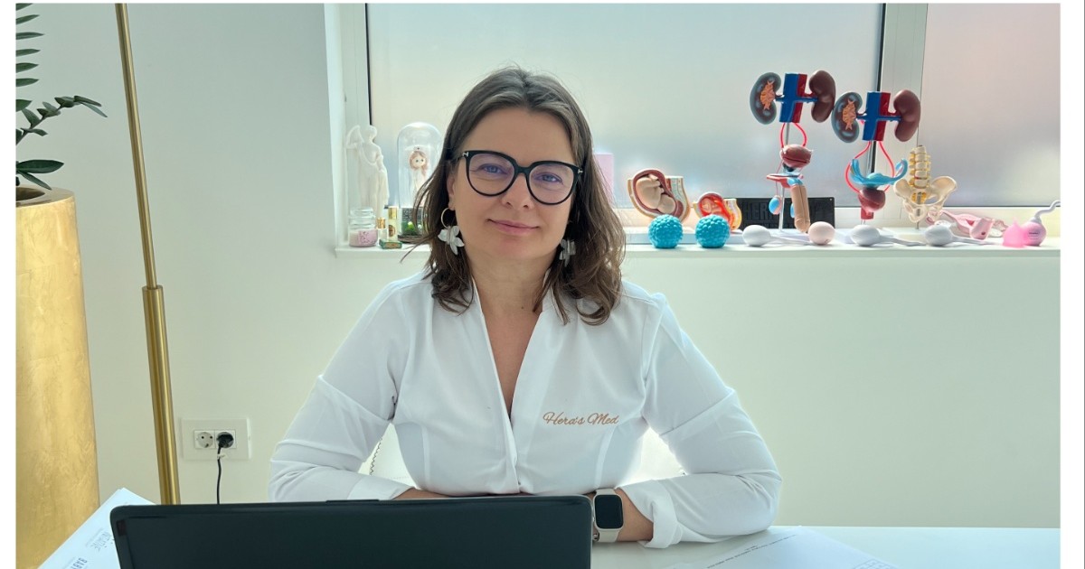 fertilizare in vitro: poza cu doamna Dr. Marilena Blu, in cabinet, asezata pe scaun, avand parul saten, purtand ochelari si o camasa alba