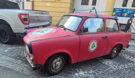 Trabantul roșu al lui Iosif Derzsi, cu sigla școlii sale. Cu un Trabant a cărat pământ și gunoi de grajd ca să transforme un teren plin de gunoaie într-o grădină cu căpșuni. Sursa foto: Turnul Sfatului