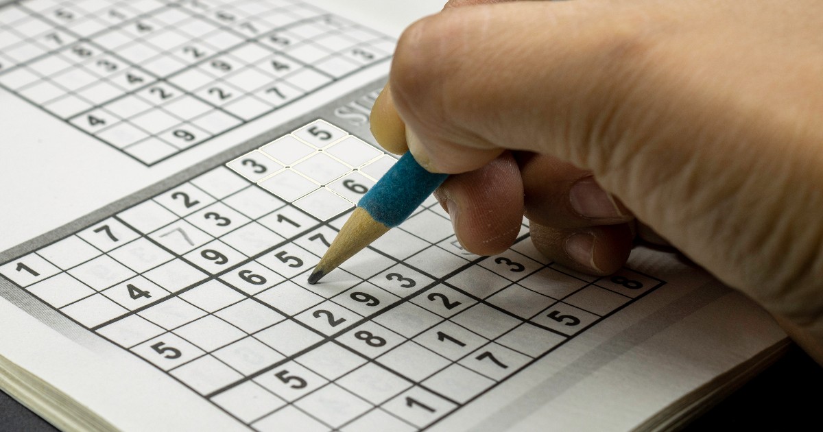 Un bărbat care rezolvă un puzzle sudoku