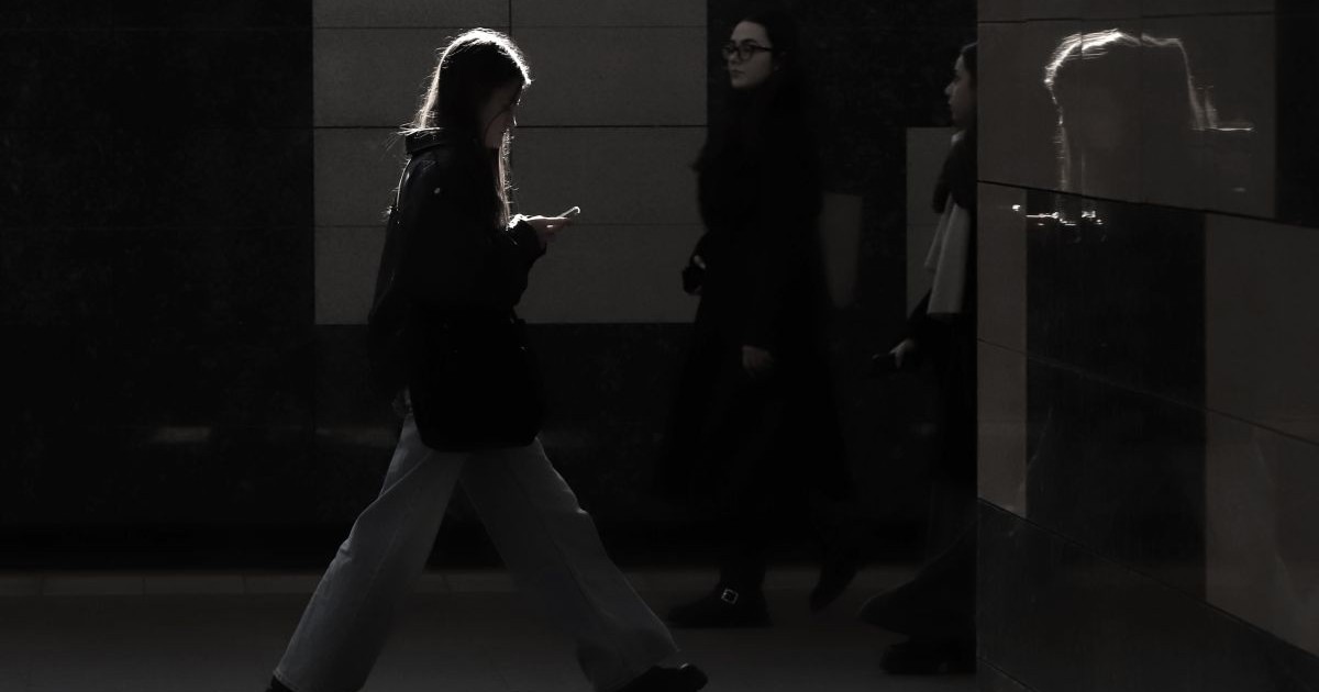 Mai multe tinere merg pe stradă, fotografia este întunecată și nu li se văd bine fețele, în București, 2026
