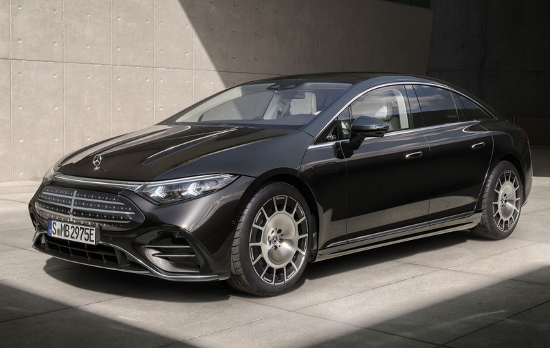 masina neagra marca Mercedes Benz modelul EQS pe un fundal gri facut din ciment