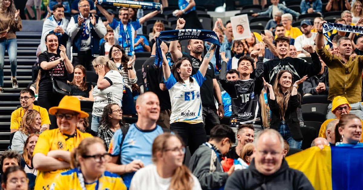 Suporteri ai echipei CSM București în tribună, în timp ce își susțin echipa favorită