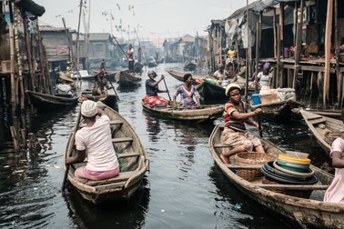 A picture taken on March 2, 2019 shows people taking boats on a waterway in the Makoko waterfront community in a polluted lagoon in Lagos, Africa’s biggest megalopolis in Nigeria. The sprawling community began in the 19th century as a fishing village for immigrants who settled on the water's edge. As more arrived and land became rare, people started to move out onto the water. Over time, Makoko became a floating realm of perhaps a quarter of a million people, although the real number is anyone's guess.,Image: 493065583, License: Rights-managed, Restrictions: , Model Release: no, Credit line: Profimedia