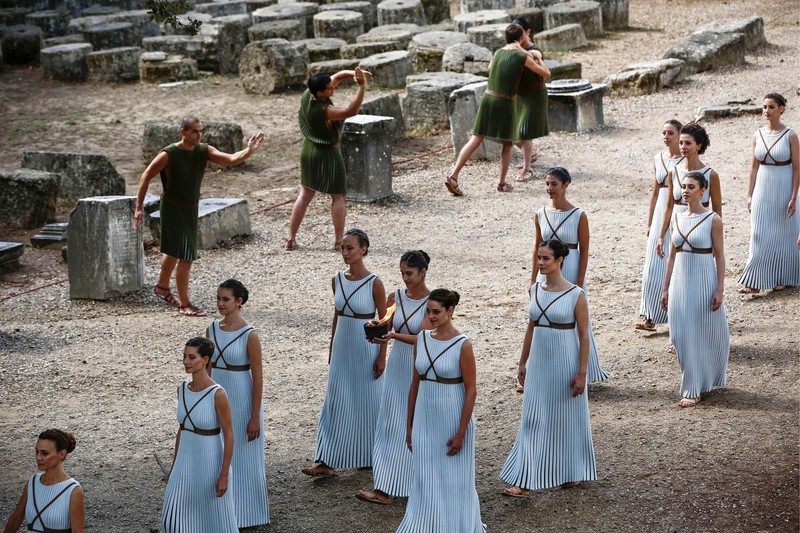 epa06285813 An actress (C), in the role of a priestess, holds an archaic pot with the Olympic Flame during the Lighting Ceremony of the Olympic Flame for the PyeongChang 2018 Winter Olympic Games in front of the Hera Temple in Ancient Olympia, Greece, 24 October 2017. The flame will make a 2,018km journey through South Korea starting on 01 November 2017. The PyeongChang 2018 Winter Olympics will be held from 09 until 25 February 2018. EPA-EFE/YANNIS KOLESIDIS