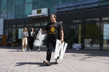 Un angajat demontează semnul McDonald’s de pe fațada unui centru comercial din Novosibirsk, Rusia. McDonald’s și-a suspendat activitatea în toate cele 850 de restaurante din Rusia, după invadarea Ucrainei | Foto: Alexandr Kryazhev / Sputnik